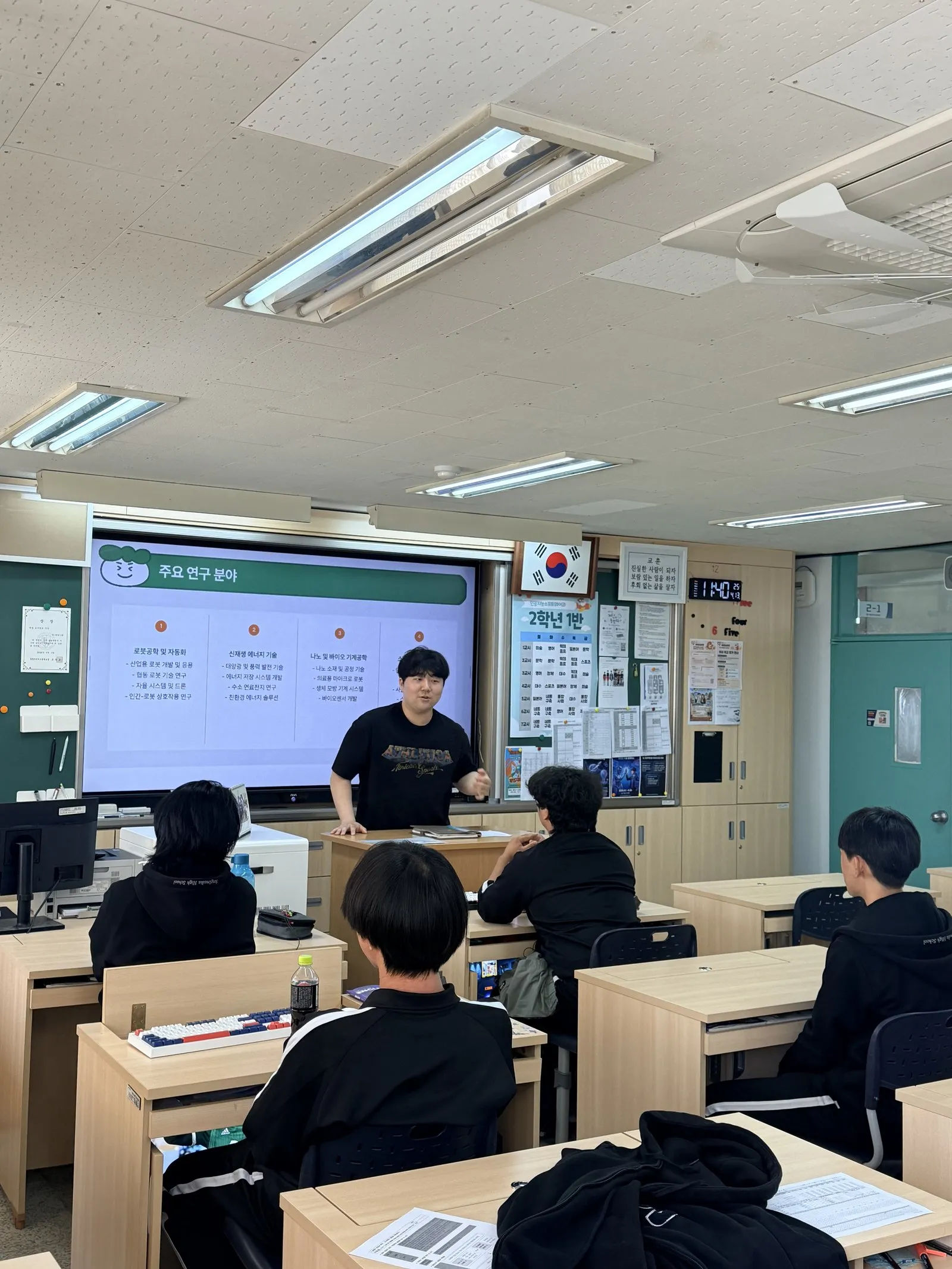 교실에서 강사가 화면 자료를 가리키며 설명하는 장면