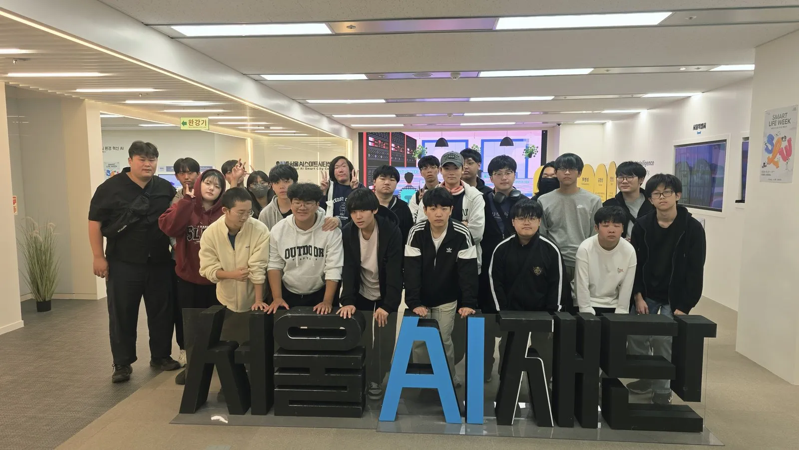 서울AI센터 표지 앞에서 기념사진을 찍는 인공지능소프트웨어과 학생들
