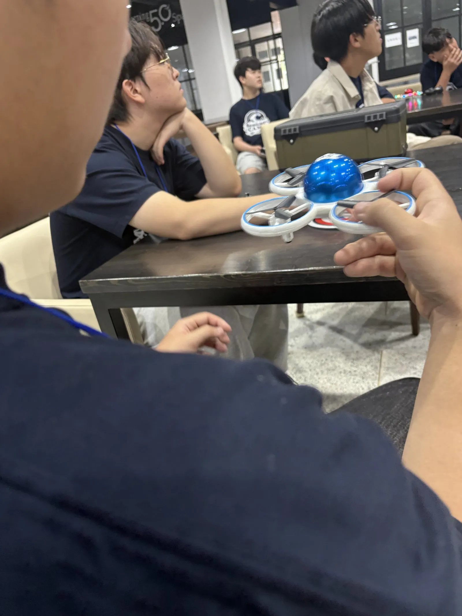 드론을 손에 들고 살펴보는 학생