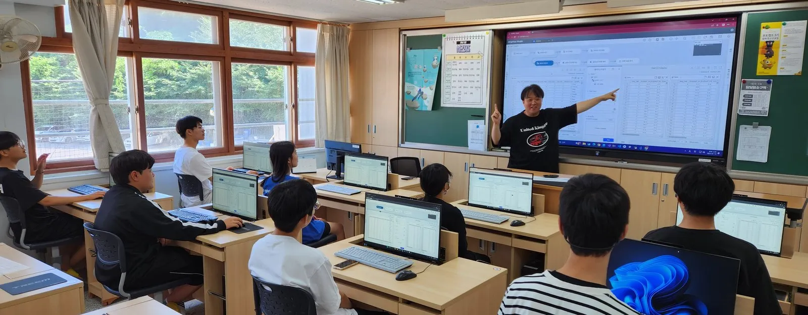 교실에서 강사의 설명을 들으며 노트북으로 실습하는 학생들
