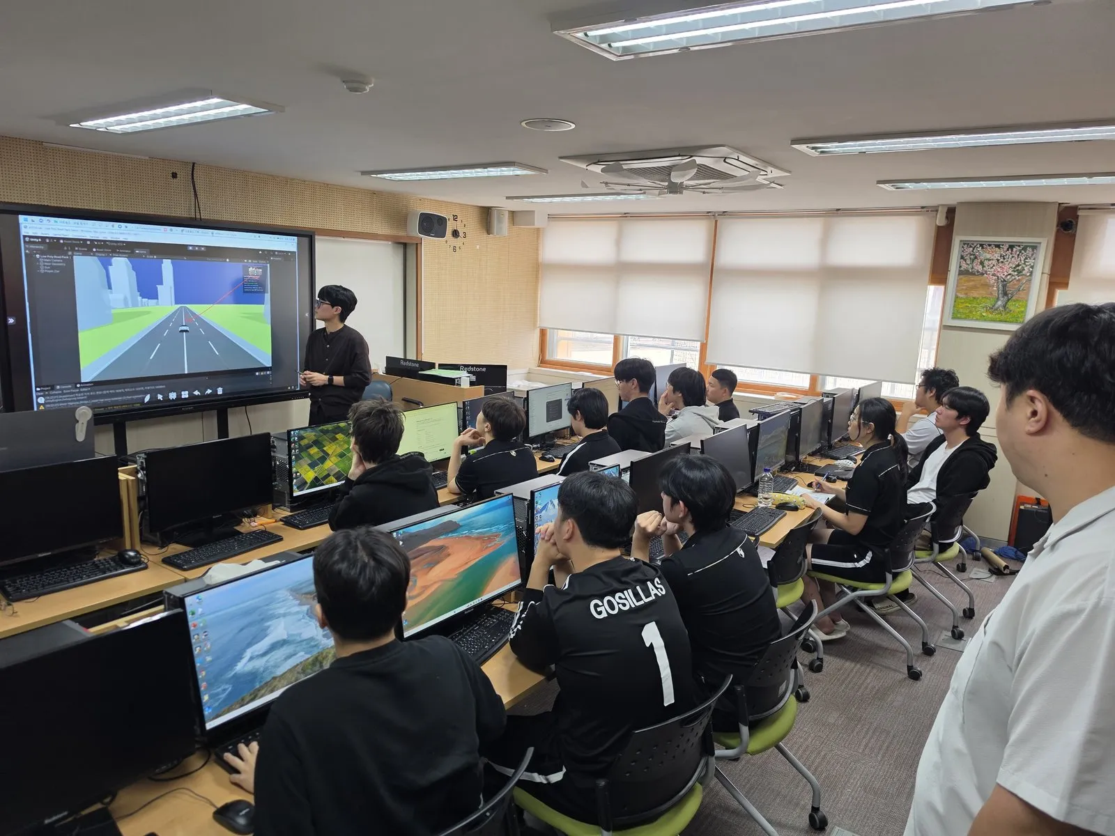 컴퓨터 실습 화면과 함께 진행되는 공개수업을 참관하는 교사들