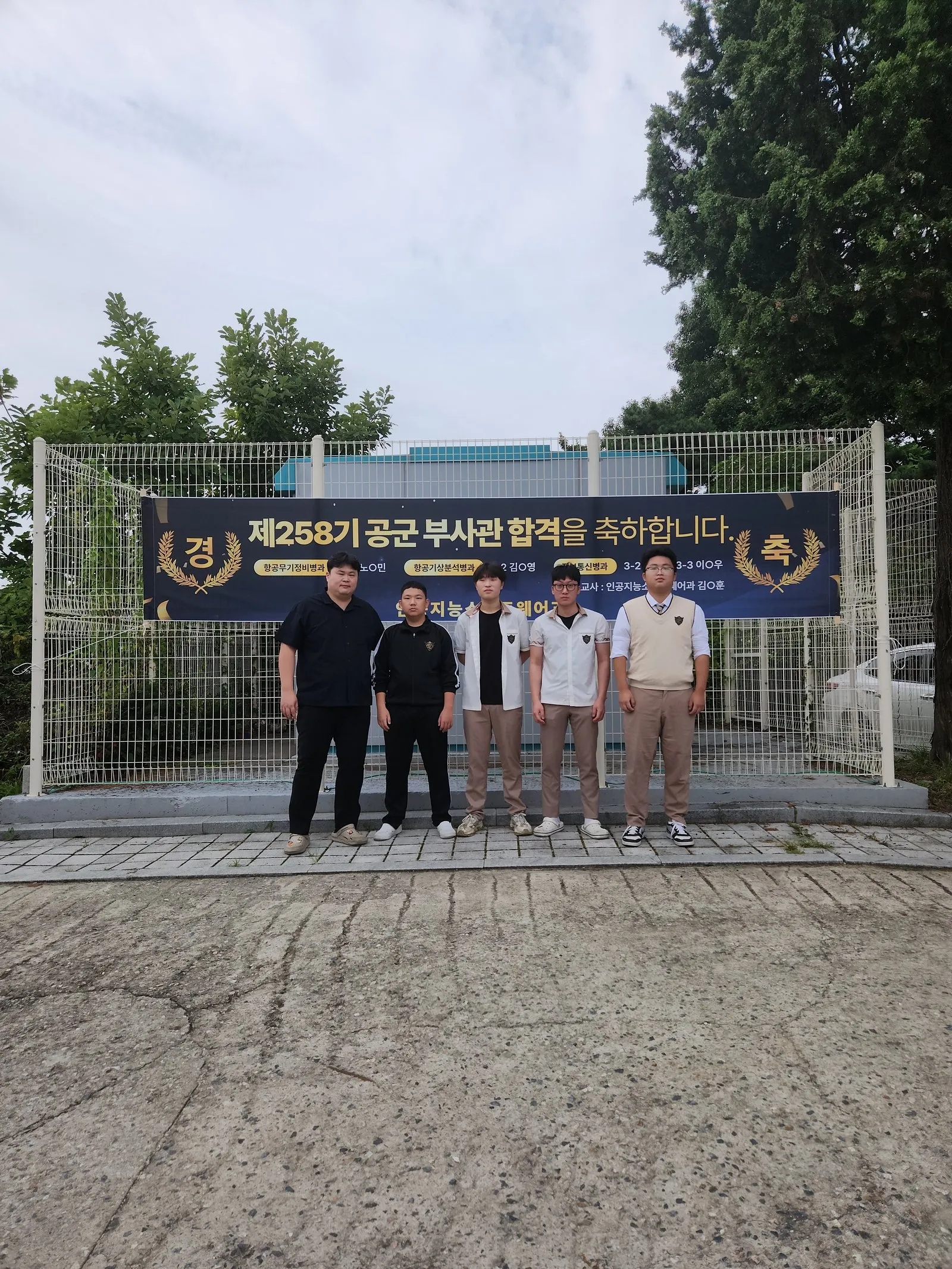 제258기 공군부사관 합격 축하 현수막 앞에 선 합격자들