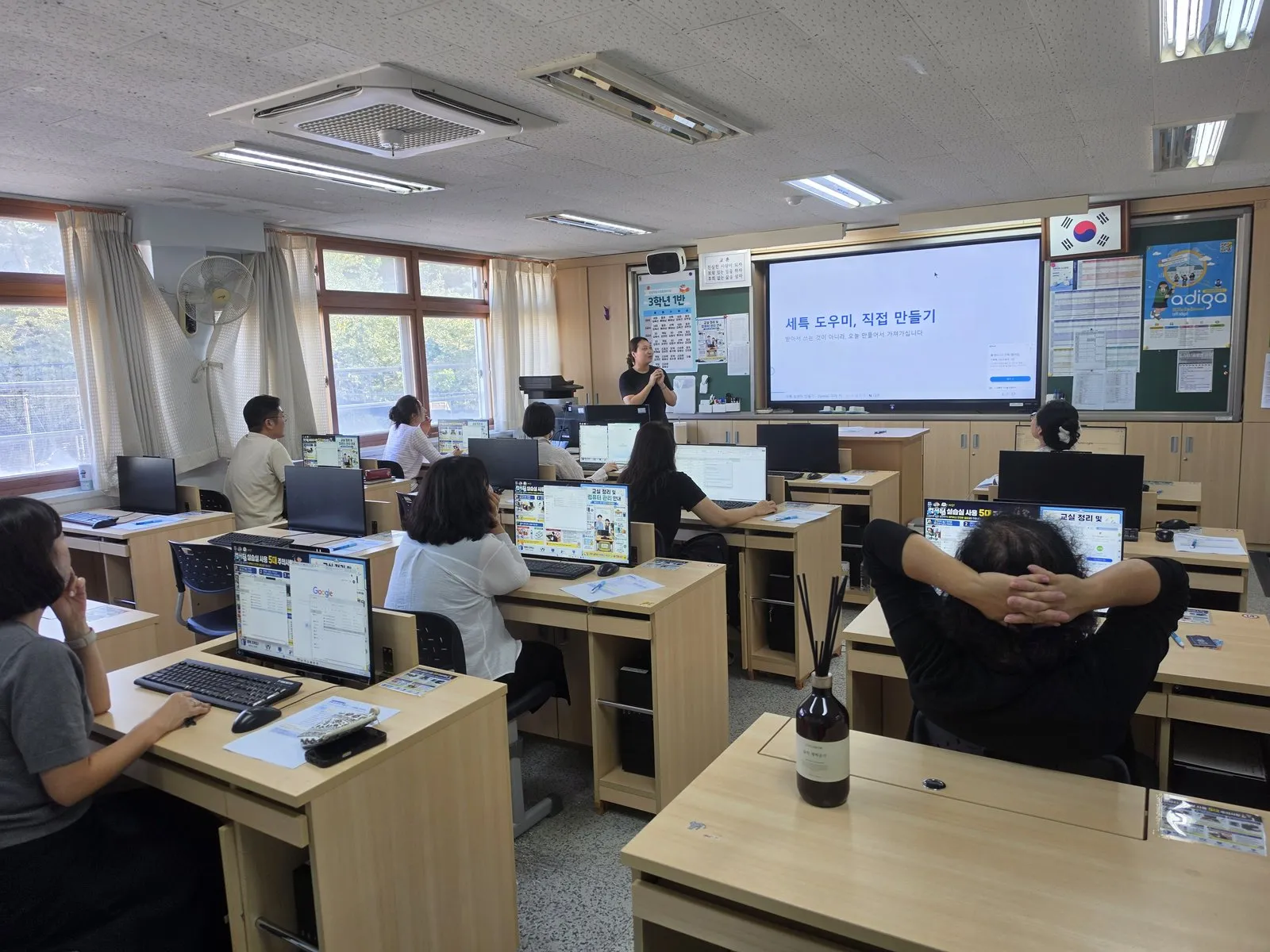 컴퓨터실에서 강사의 설명을 듣는 교사 연수 참가자들