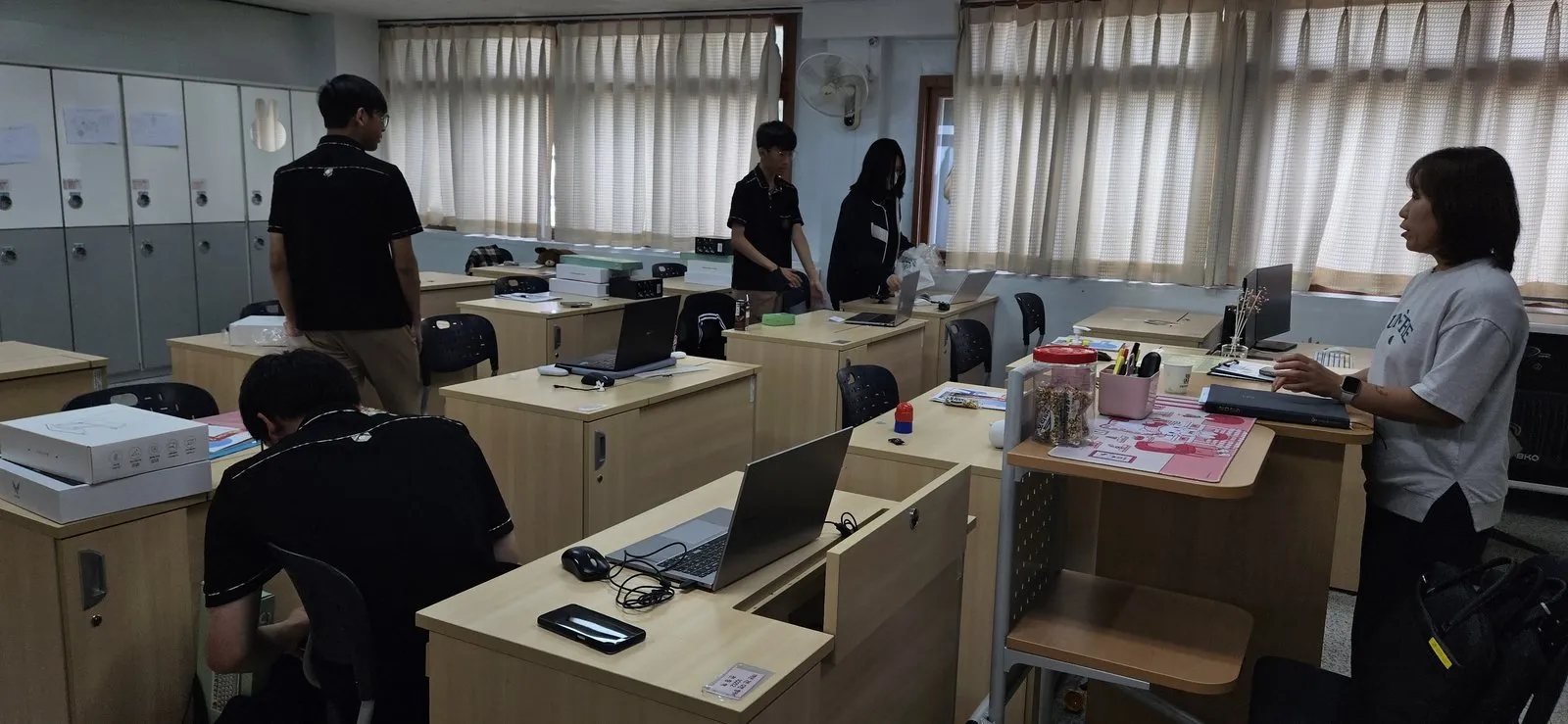 교사가 학생의 화면을 보며 지도하는 장면