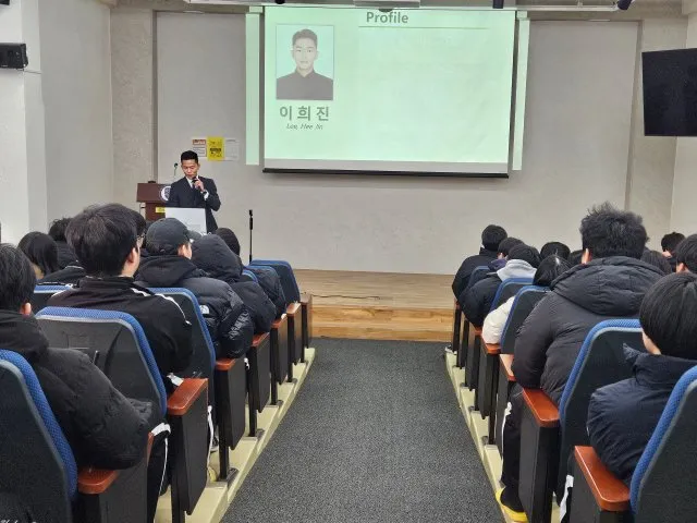 졸업생 프로필을 띄운 화면 앞에서 강연하는 모습