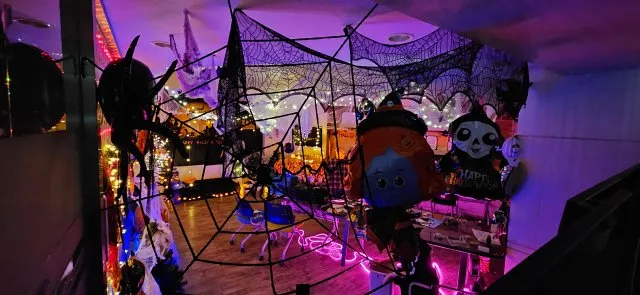 HAPPY HALLOWEEN 현수막과 유령 풍선 앞의 트리 장식