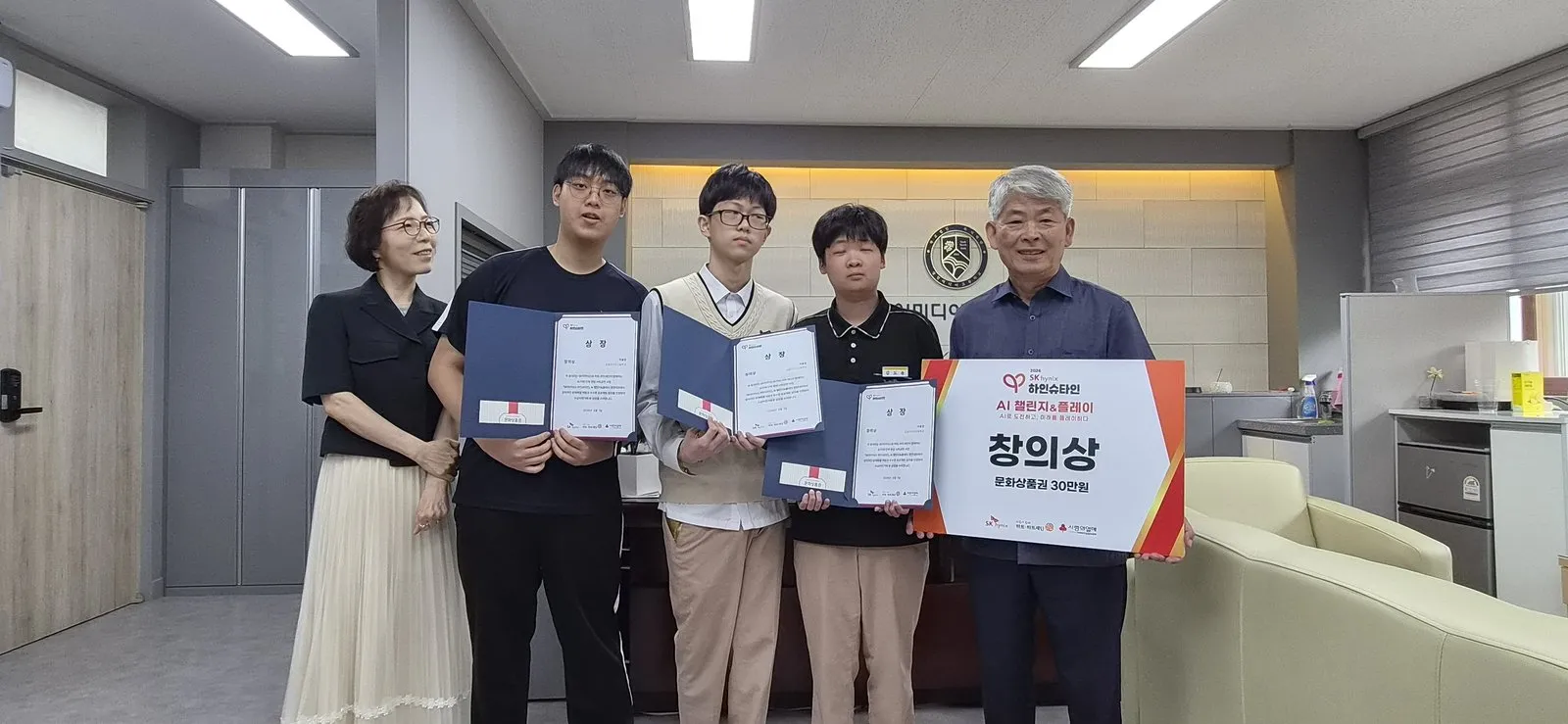 교장실에서 창의상 팻말과 상장을 든 수상 학생들과 교장 선생님