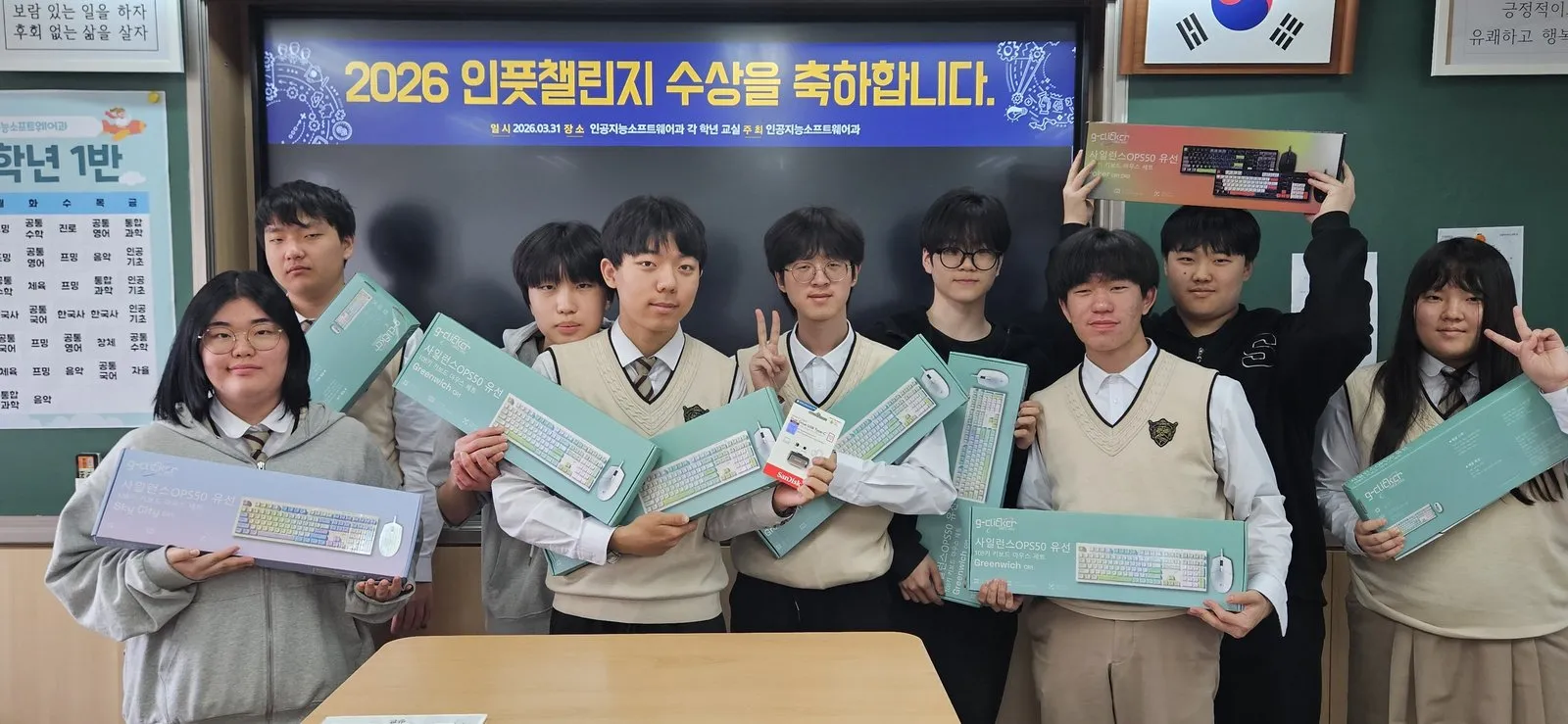 '2026 인풋챌린지 수상을 축하합니다' 화면 앞에서 부상으로 받은 키보드·마우스 세트를 든 학생 8명